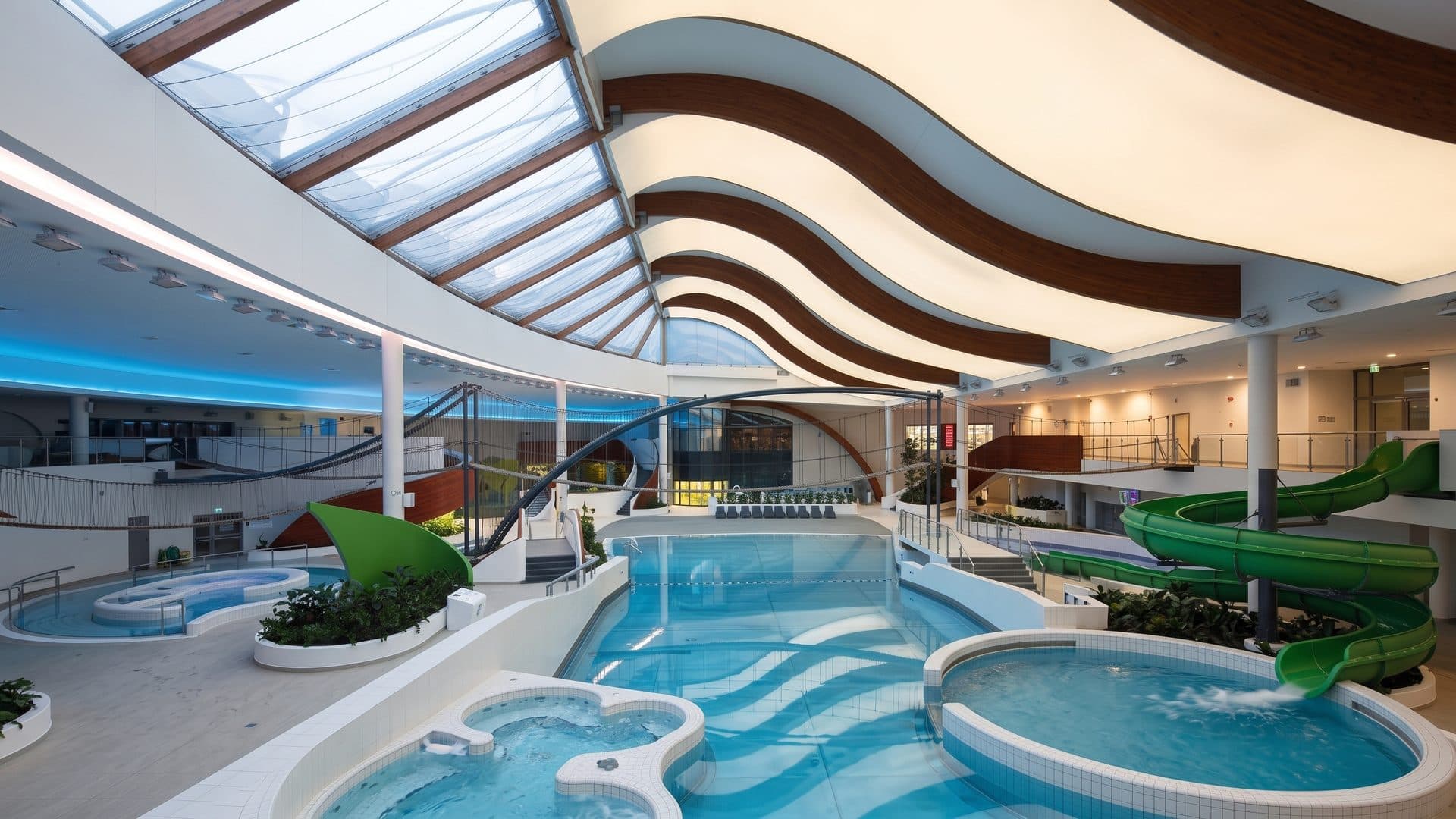 The hall of Wodny Park Tychy with its curved roof above the pools and slide