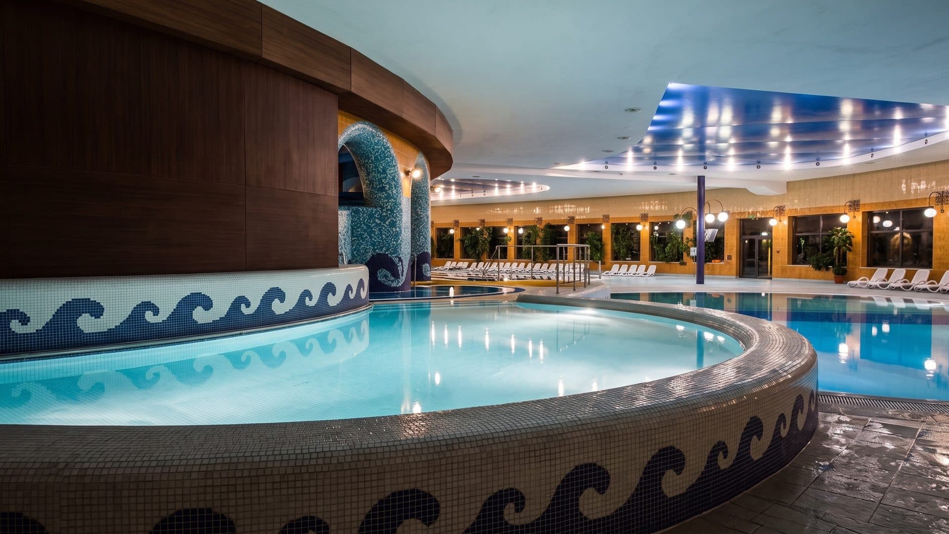 The round leisure pool of Wodny Raj in Swarzedz with a wave mosaic rim and arched walls