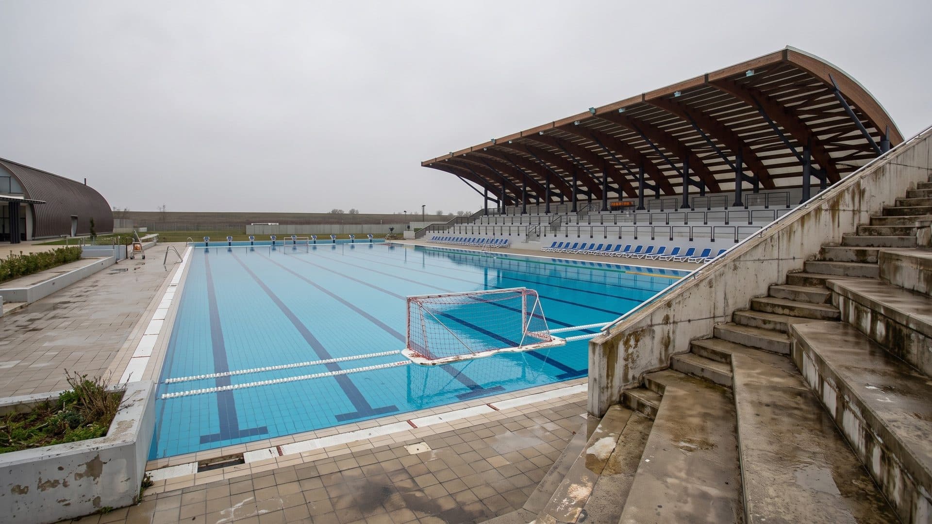 The 50-metre outdoor pool of the x-bionic aquatic sphere in Samorin with water polo goals and a curved grandstand roof