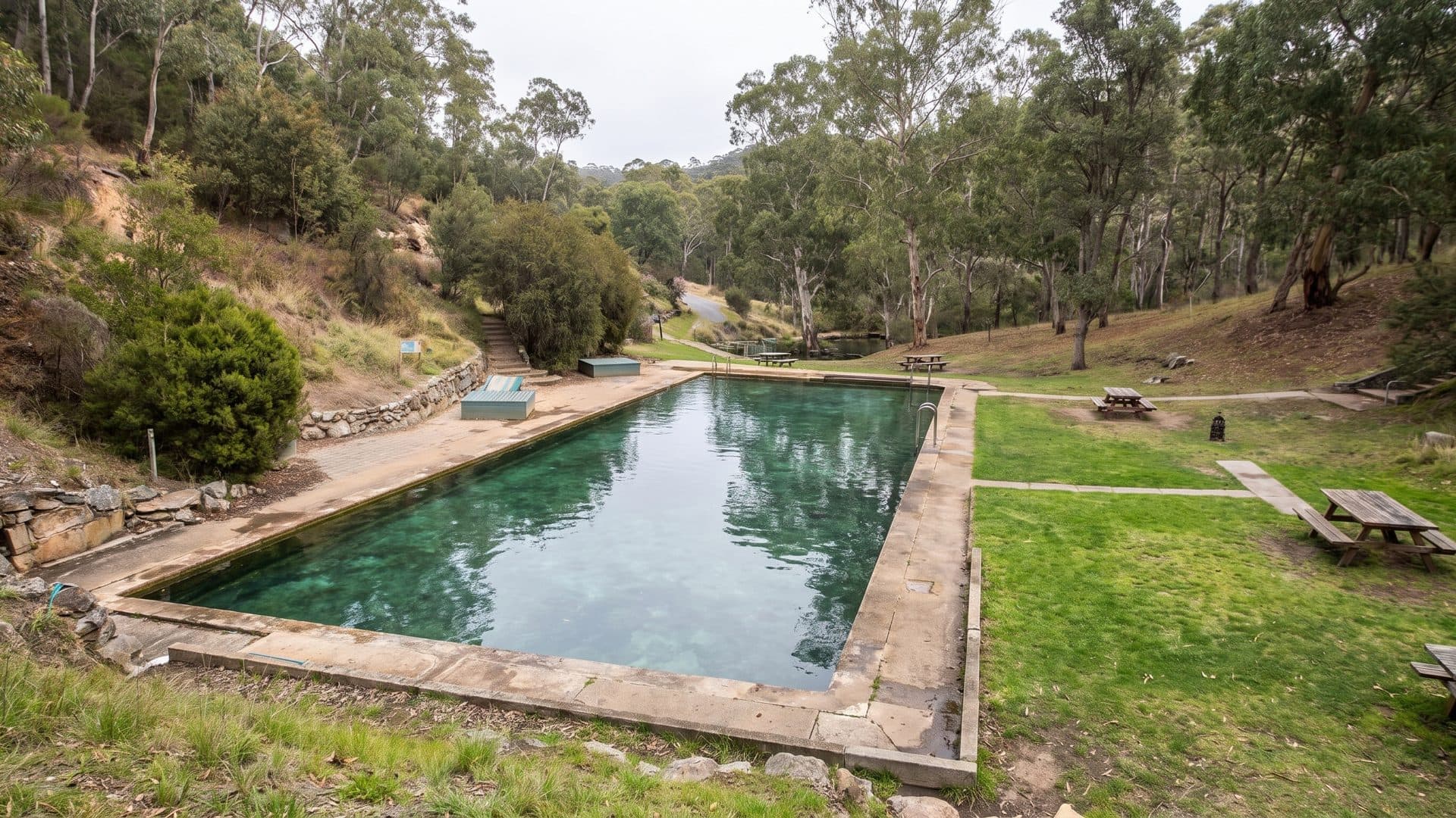 The rectangular thermal pool at Yarrangobilly in its grassy clearing among the eucalypts of the valley