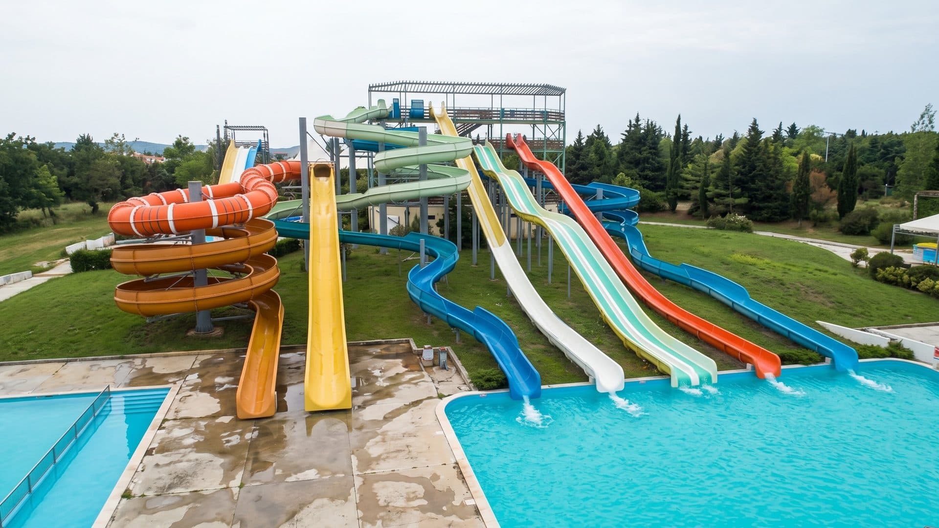 A row of coloured slides running down into the outdoor pool of the Zurbagan water park in Sevastopol