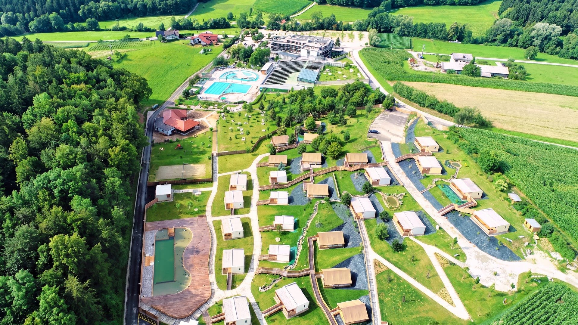 Aerial view of the pools and the holiday village among fields
