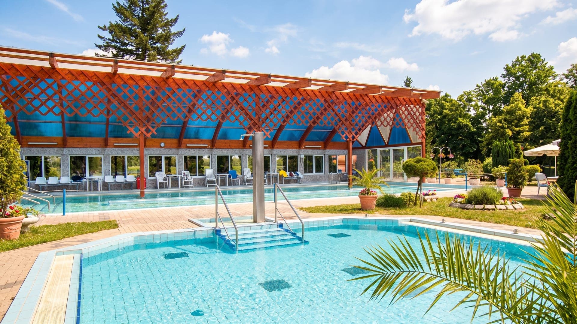 The pools at Borgata Termalfurdo, the timber-shaded hall on one side and planted tubs along the terrace.