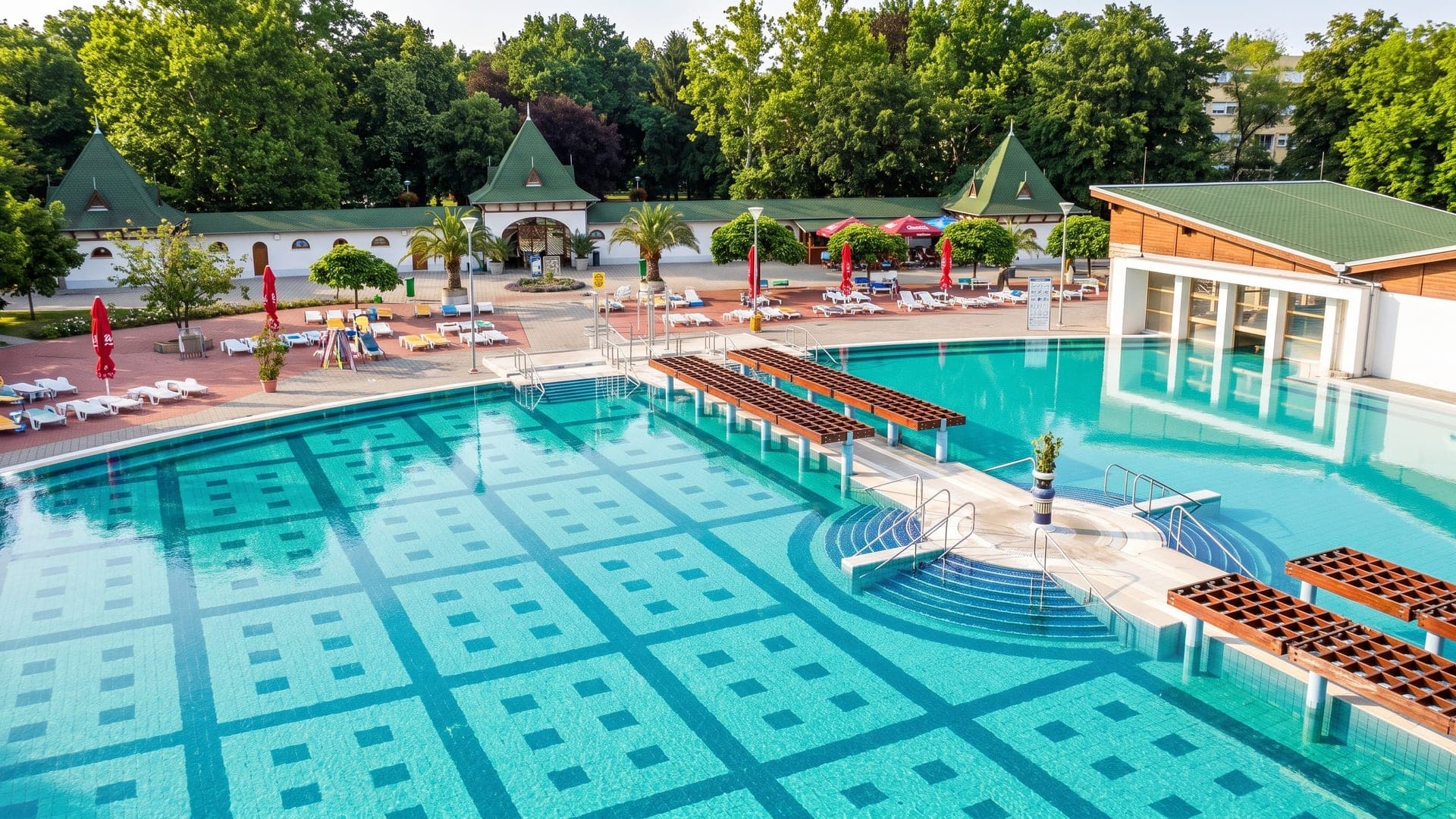 The outdoor pools at the Harkany thermal bath, with green pagoda-roofed pavilions and palms around the terrace.