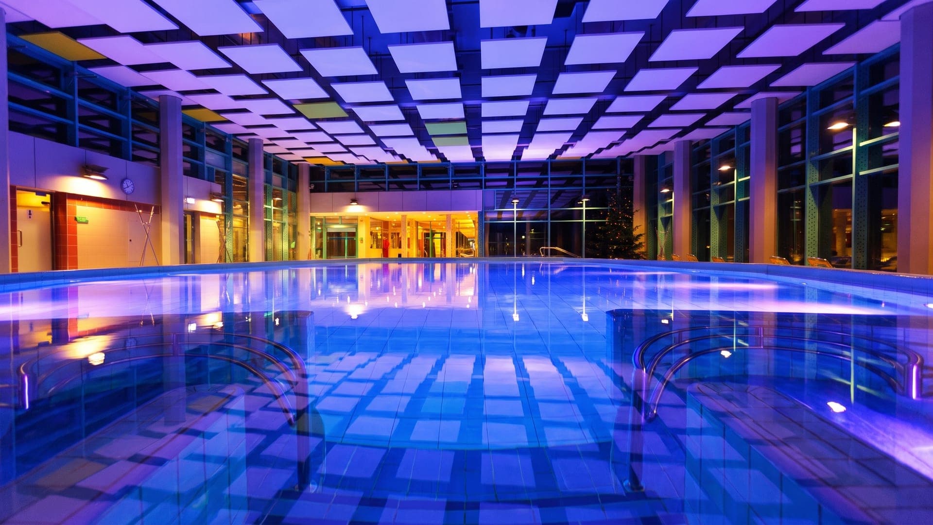 The indoor pool at the Jod-Sole-Therme in Bad Bevensen under a violet-lit coffered ceiling.