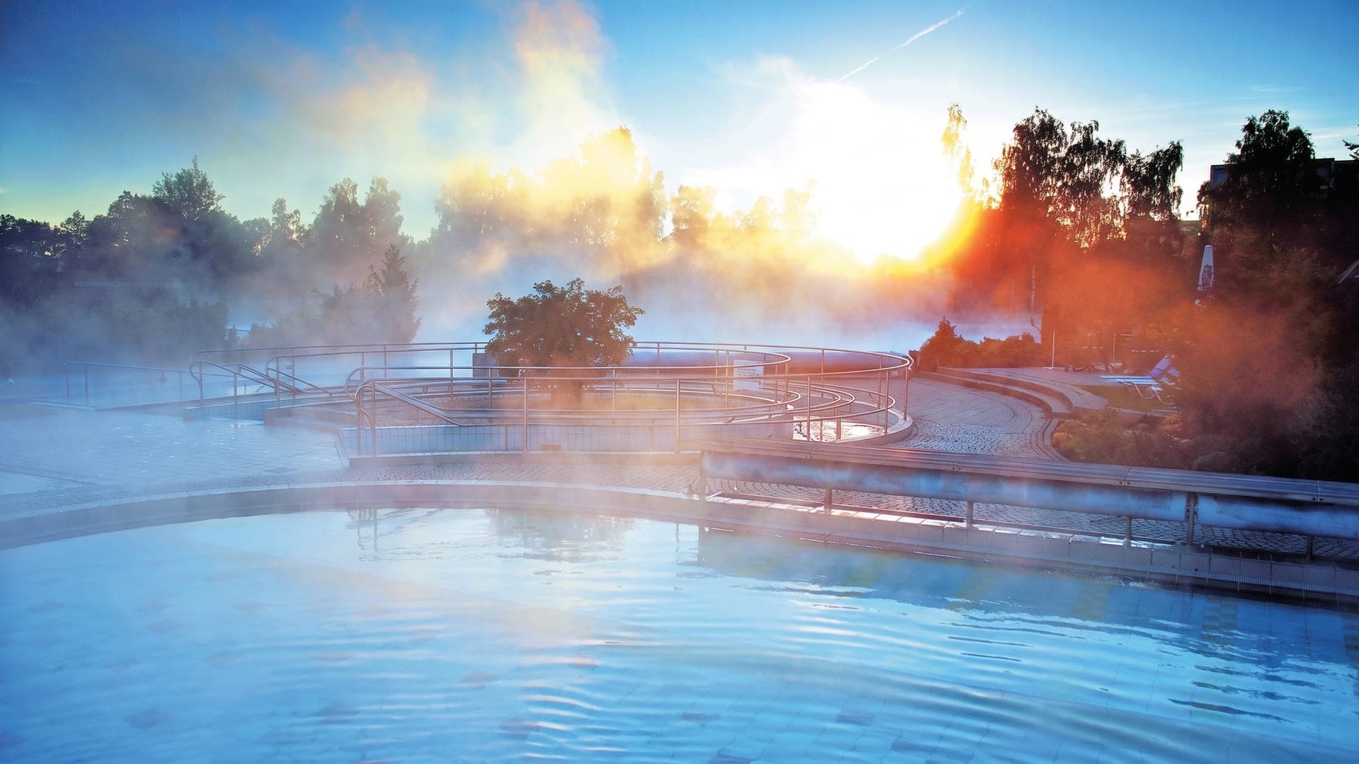Steam rising from the outdoor thermal pool at the Johannesbad Therme in Bad Fuessing at sunrise.