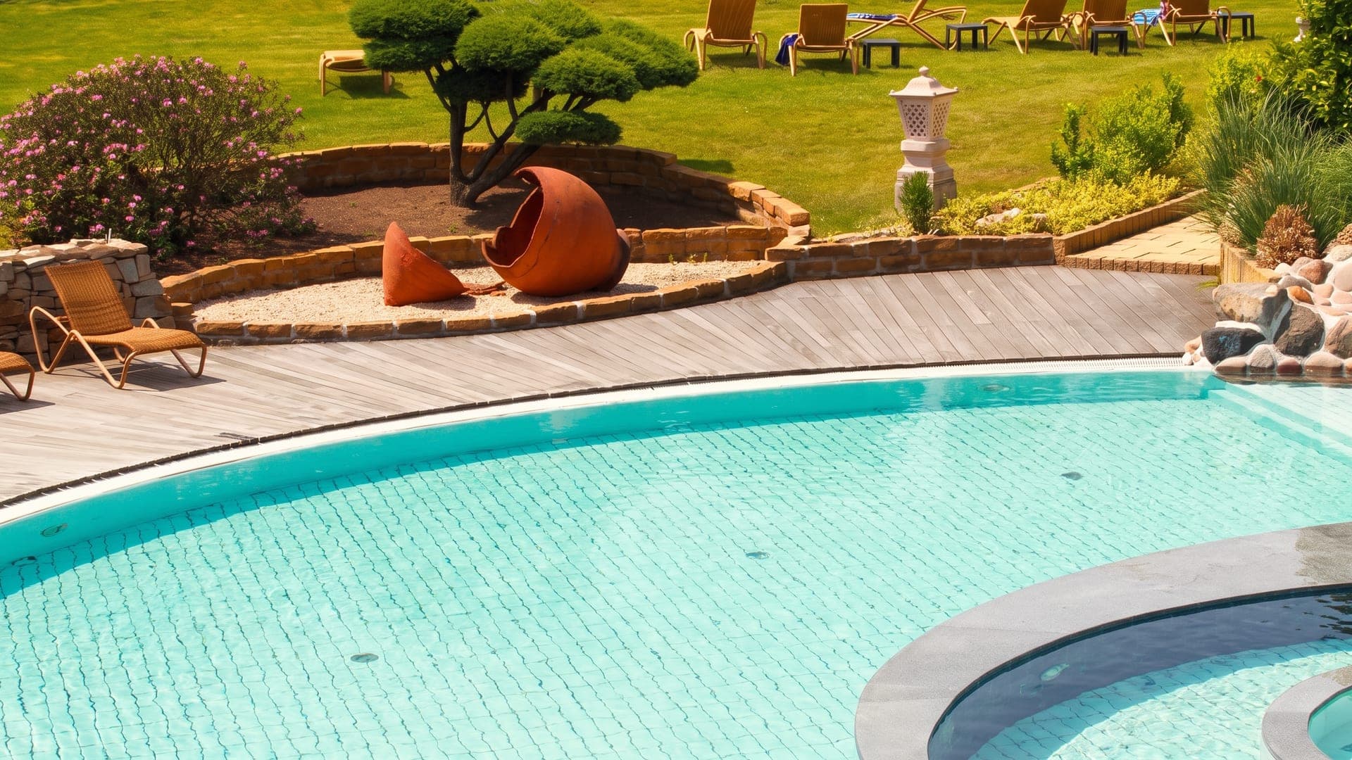 The outdoor pool at the MediTherme in Bochum, set in a planted garden with a large earthenware urn on the bank.