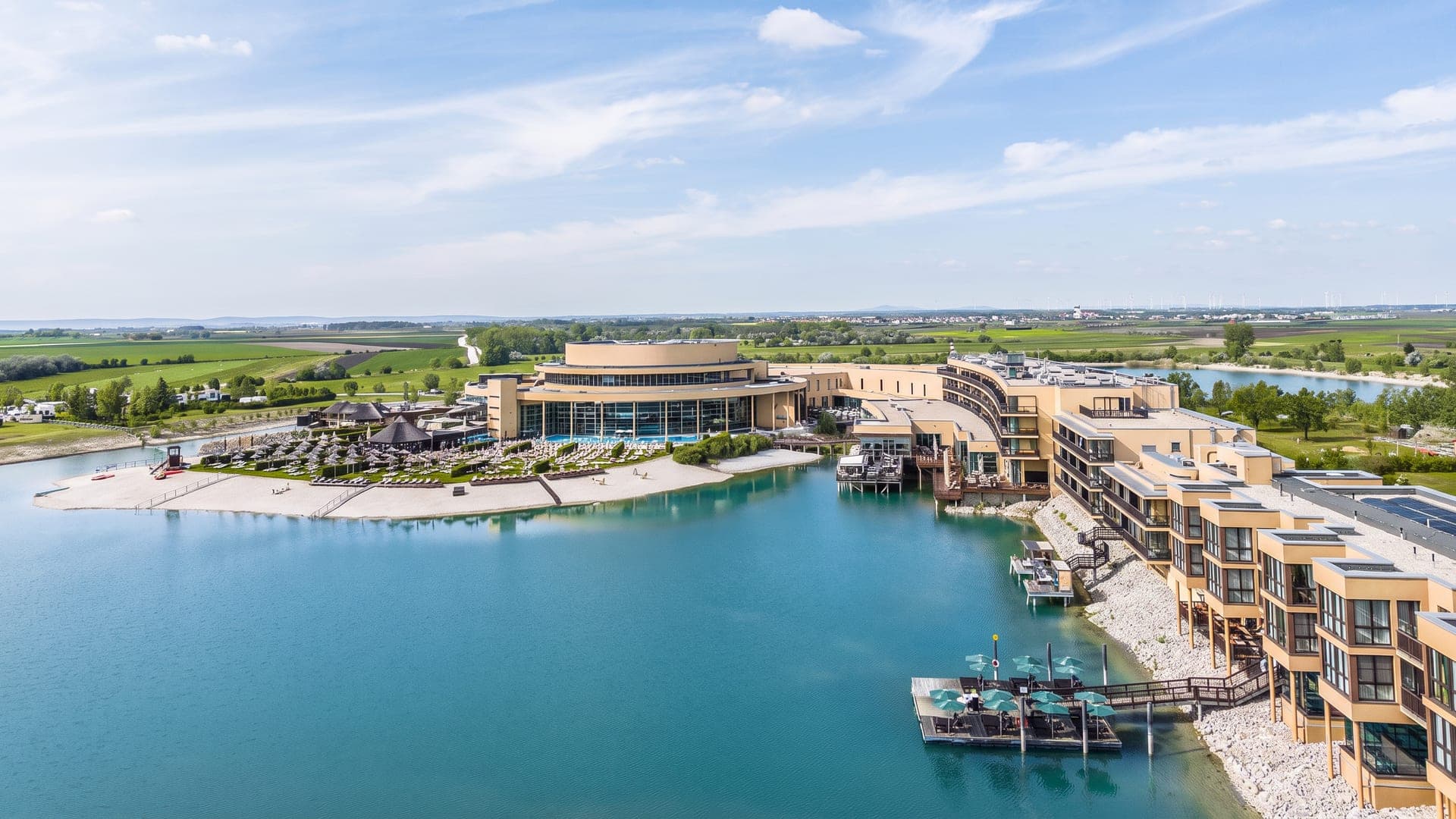 Aerial view of the resort along its lagoon, with jetties and lodges at the water's edge