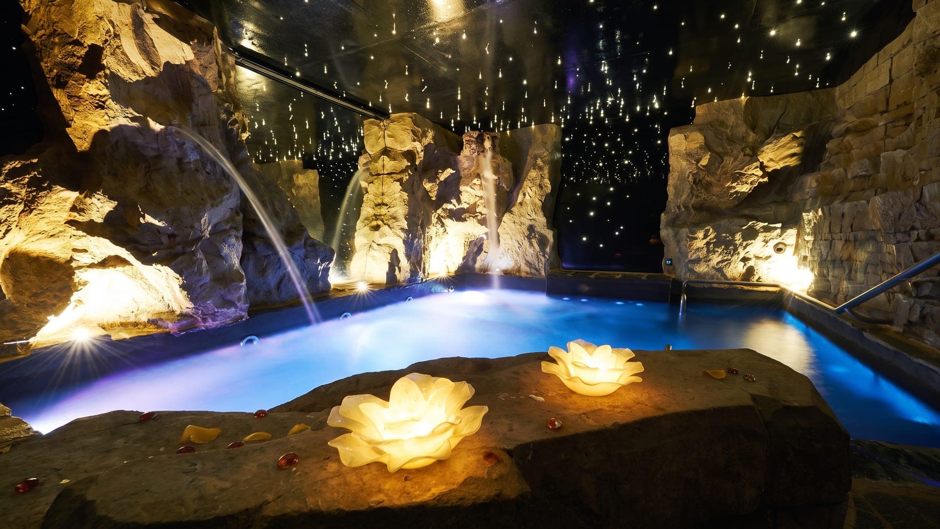 The grotto pool at Terme di Montepulciano, lit among rock walls under a ceiling of fibre-optic stars.