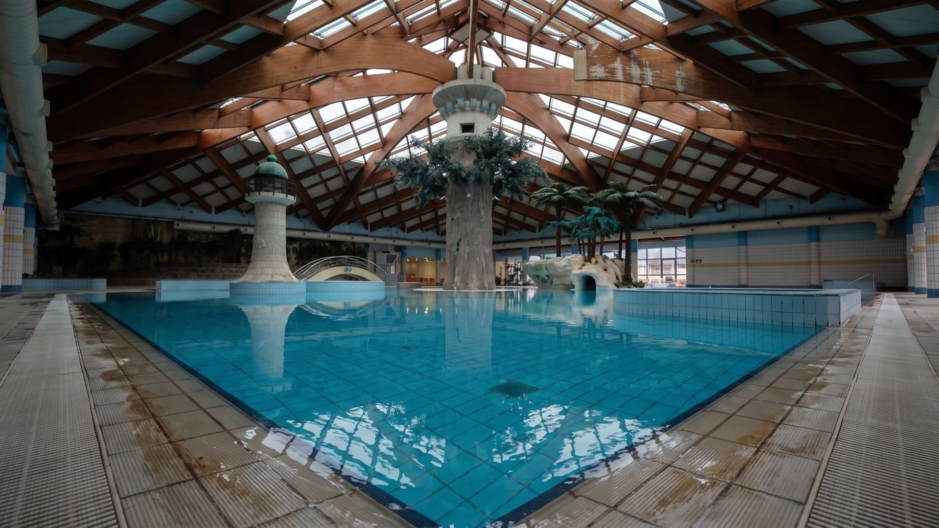 The glass-roofed bathing hall at Ilidza, a bright blue pool between rows of columns