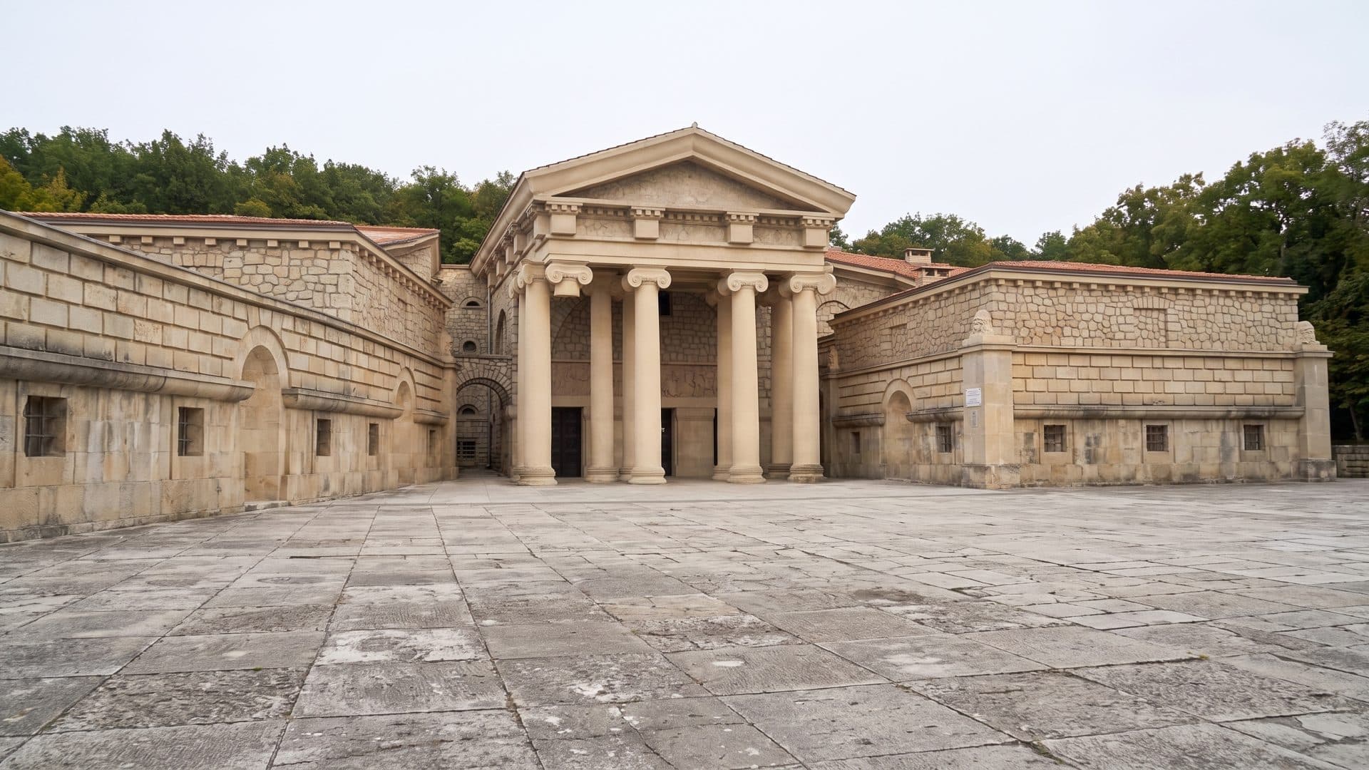 The Semashko mud baths in Yessentuki from across the paved courtyard, the columned portico standing between its two long rusticated wings